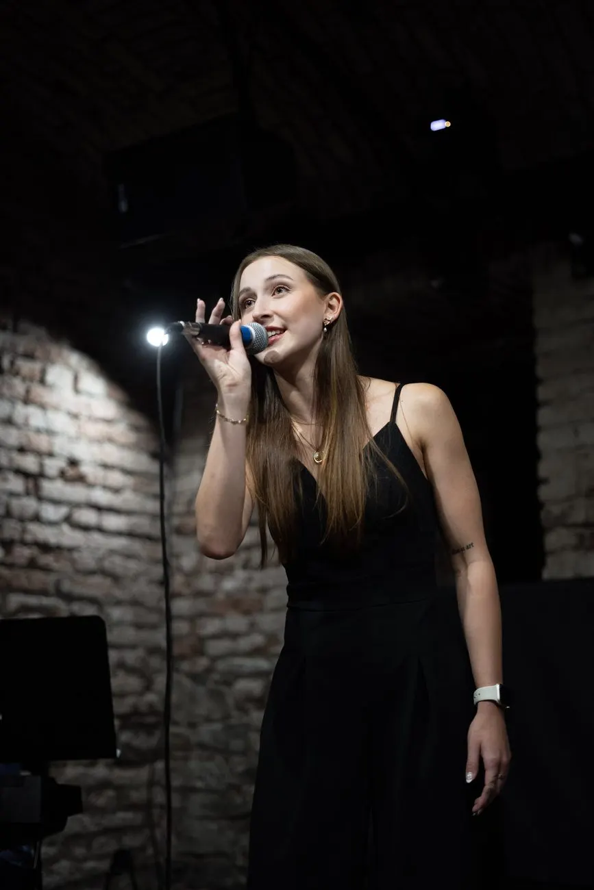 Zpěvačka s mikrofonem na pódiu v Everything Pardubice